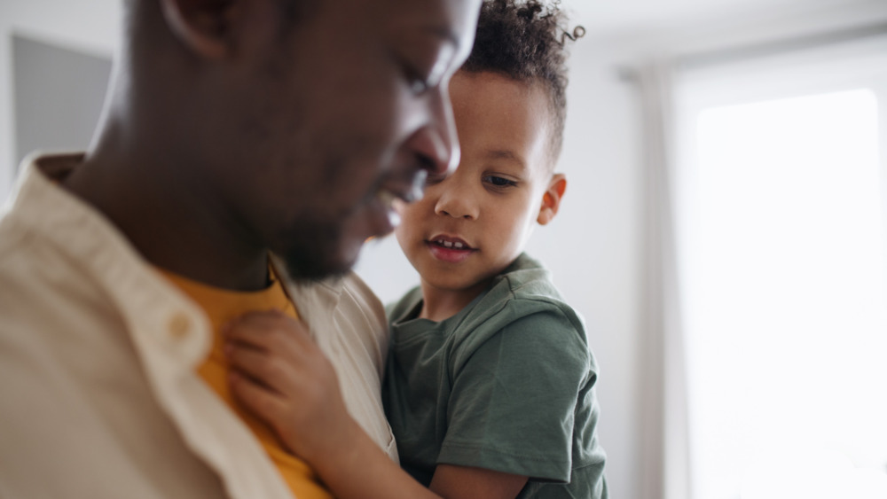 Close up of a father holding his young son.