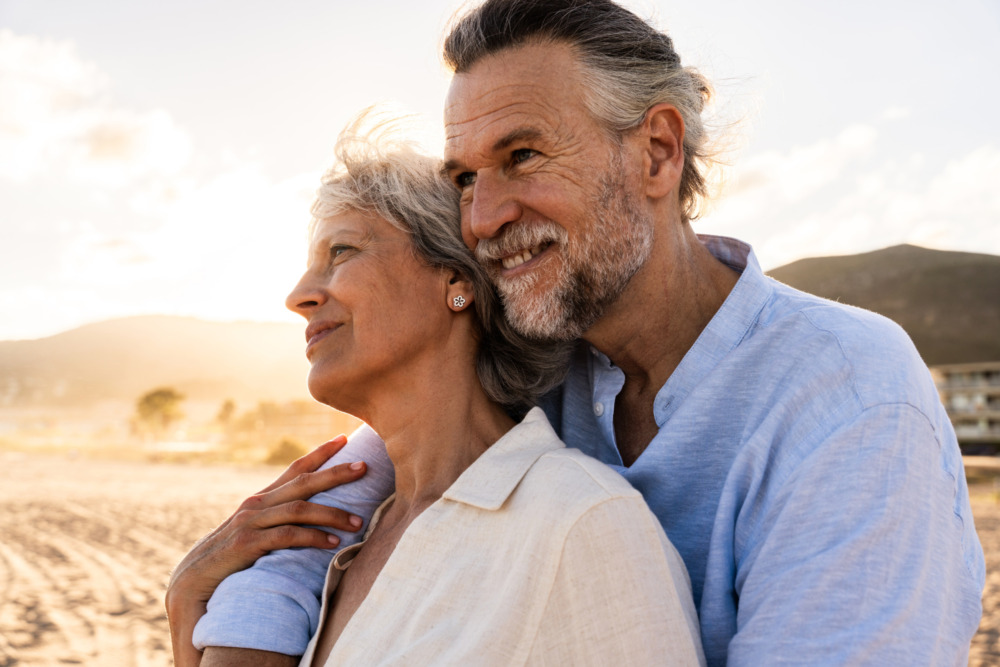 Happy older couple embracing on a beach.